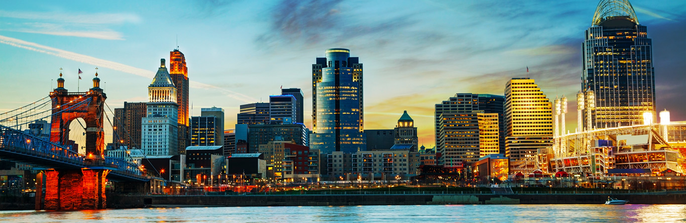 city skyline behind river at dusk